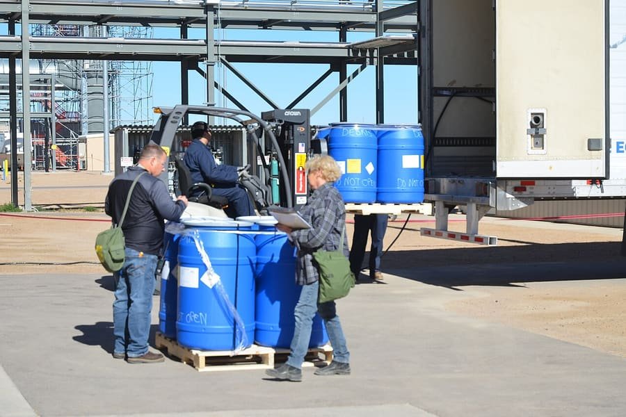 Drums of industrial catalyst on pallets being handled at a plant